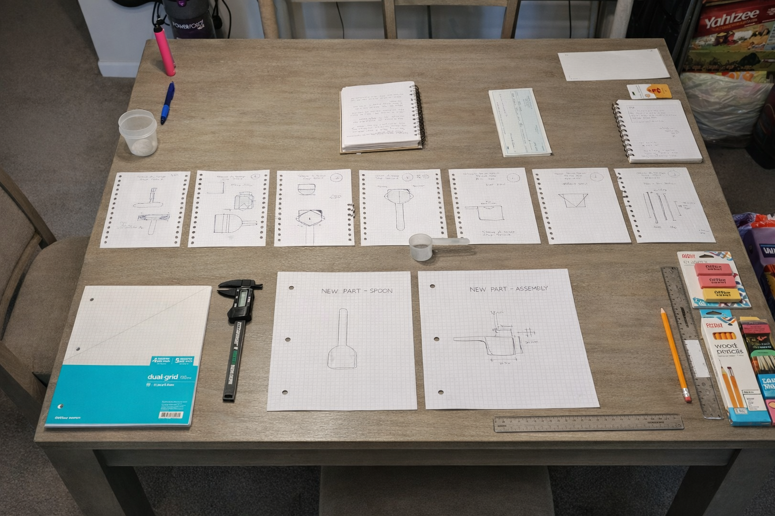 Engineering drawings and design iterations spread across a table